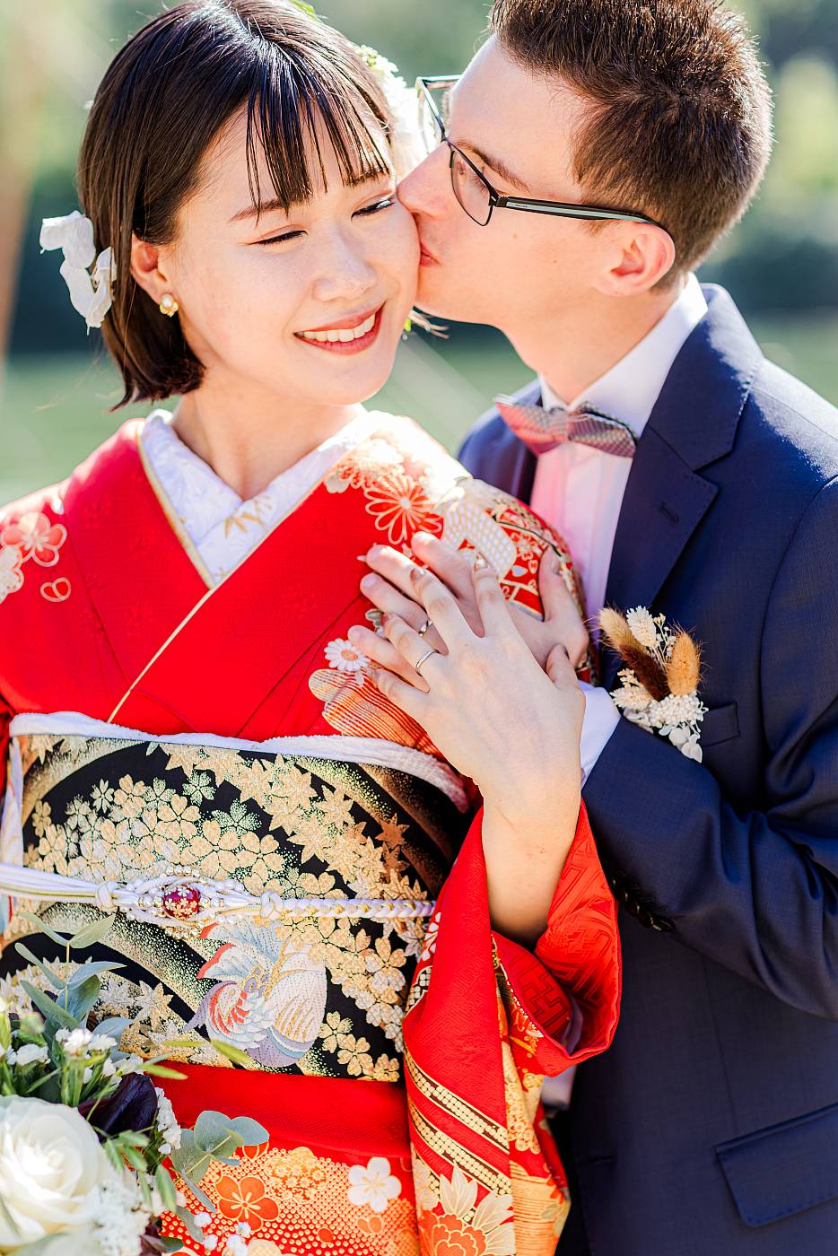 Baiser sur la joue de la mariée et gros plan sur les alliances