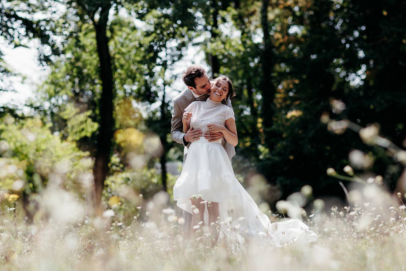Les mariés s'amusant parmi les fleurs sauvages d'un parc des Yvelines