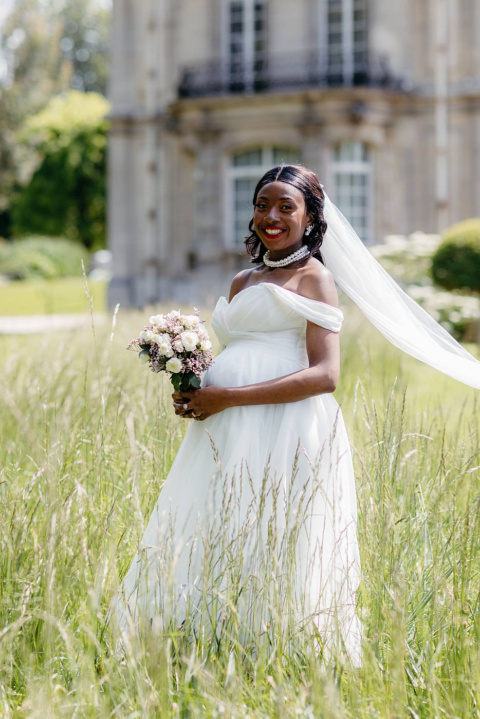 La mariée son bouquet et sa traîne dans les hautes herbes