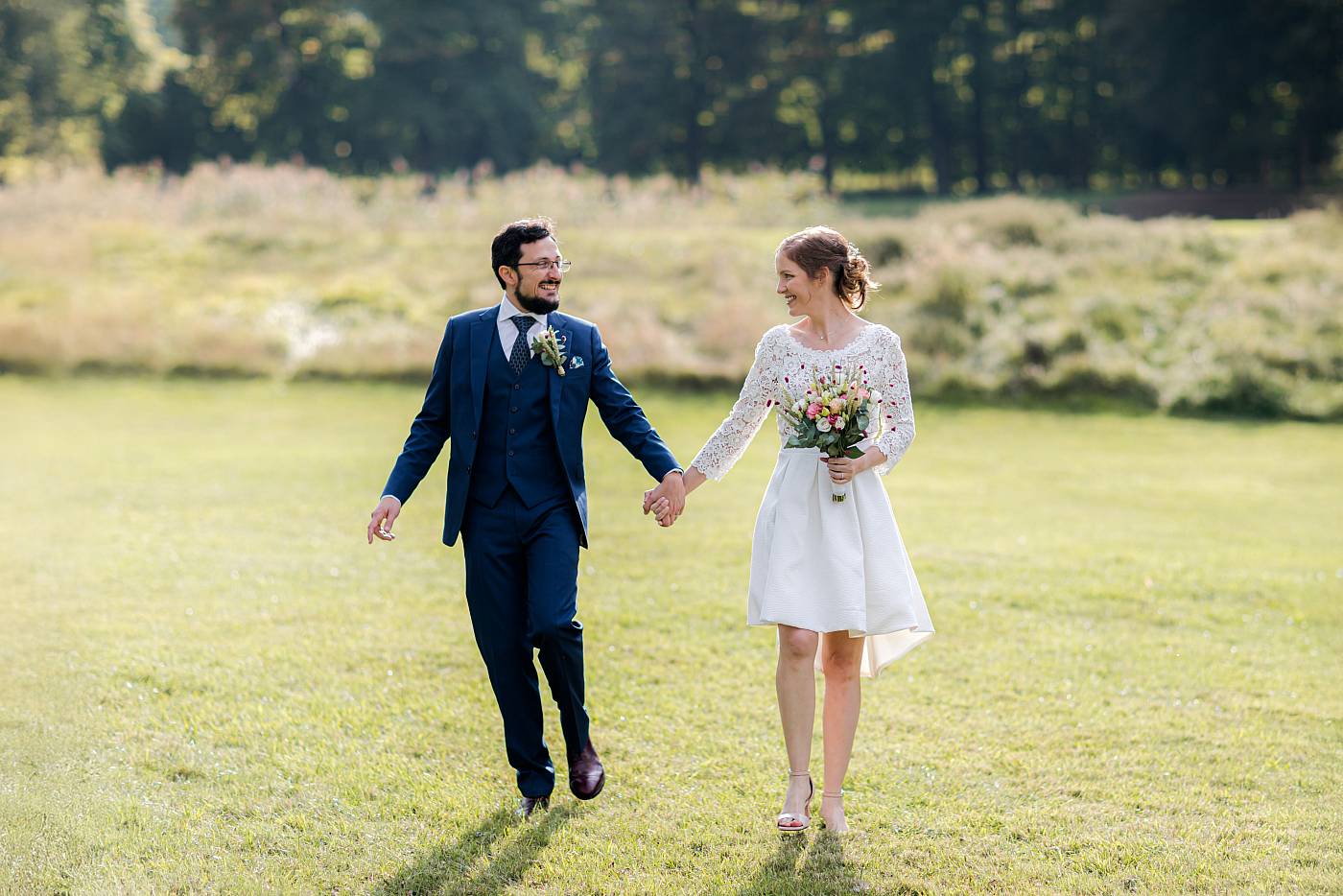 Les mariés marchent main dans la main au domaine de Marly-le-Roi dans les Yvelines