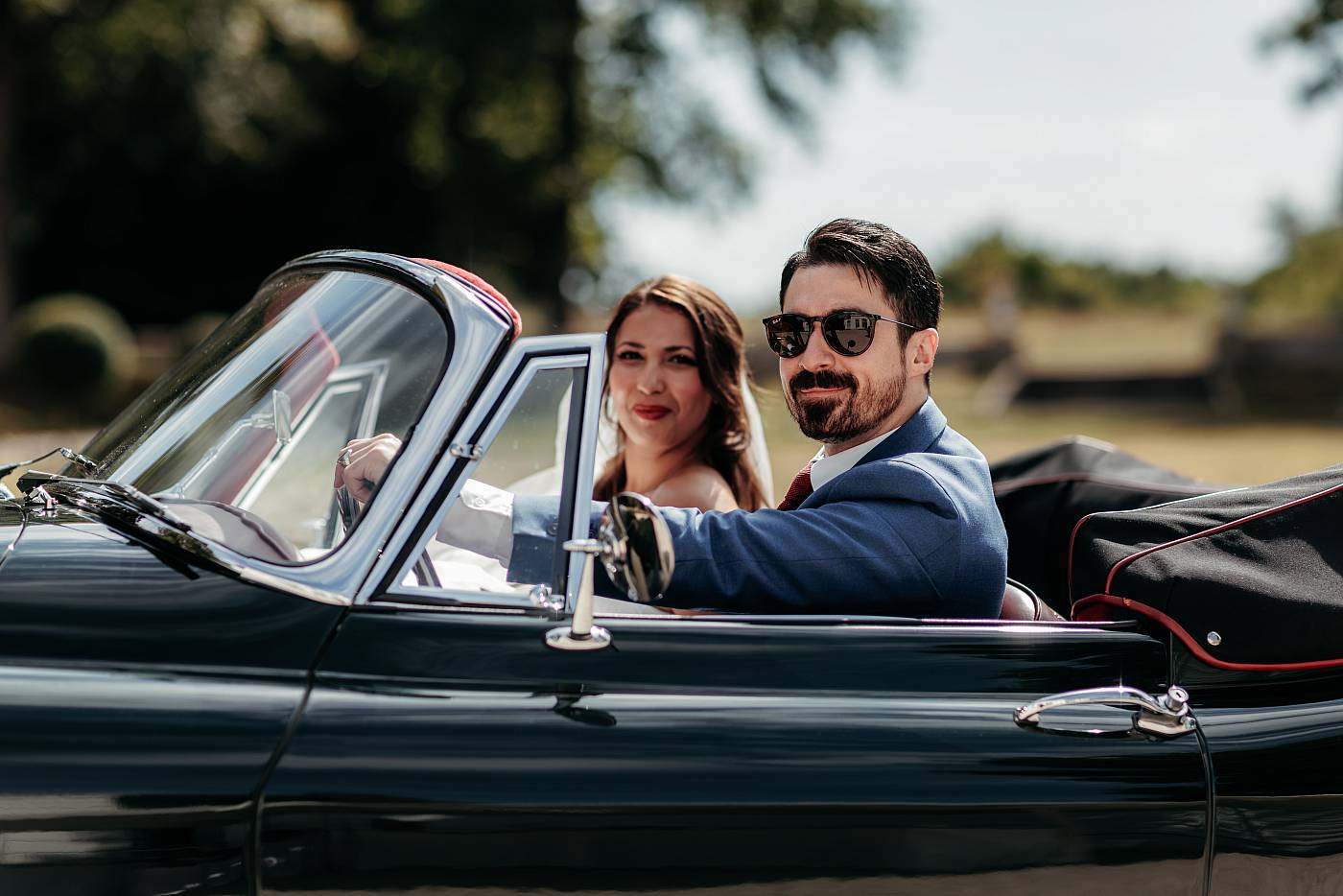 Les mariés prennent la pause dans leur jolie voiture de location