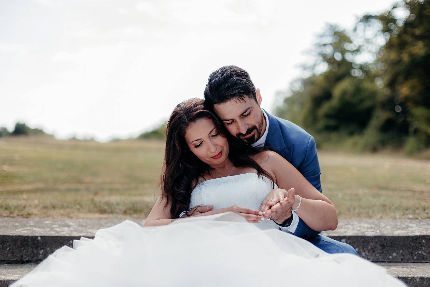 Séance tendresse entre les mariés assis sur les marches du jardin du château de Breuil