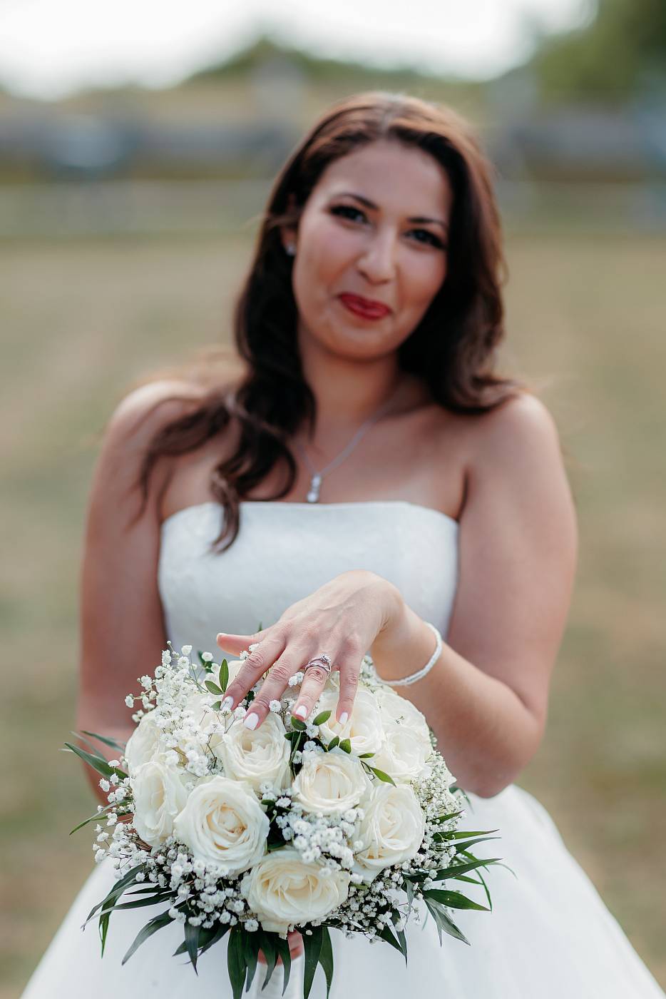 Gros plan sur le bouquet de la mariée et son alliance