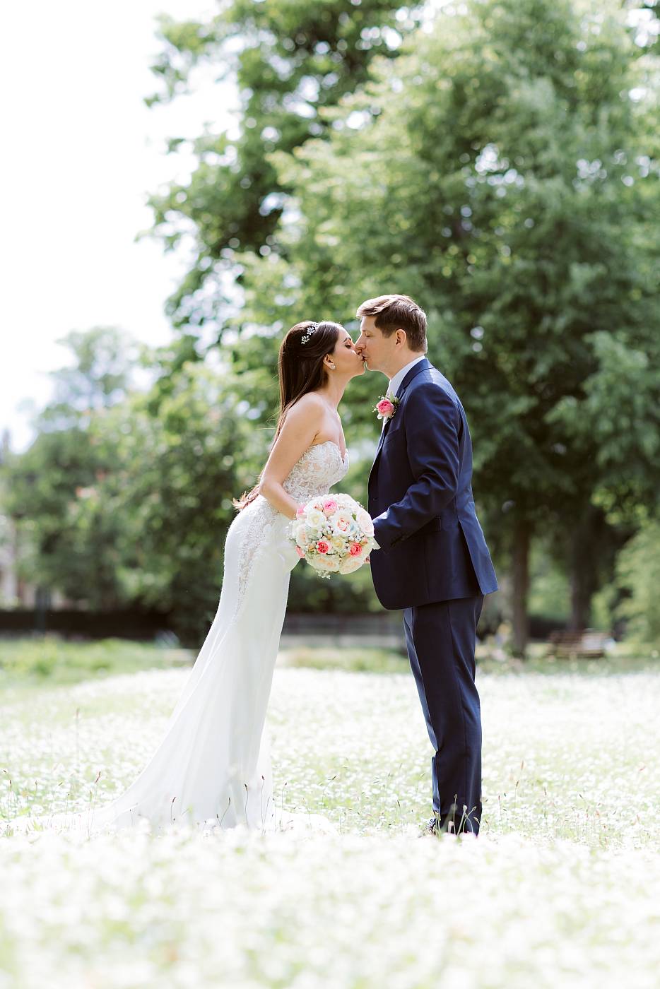 Le baiser des mariés dans les pelouses jonchées de fleurs du parc des Ibis