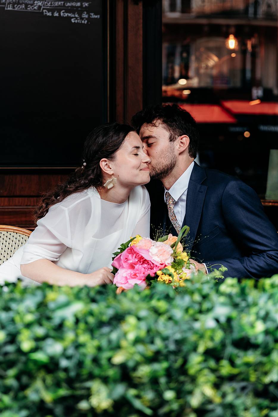 Petit baiser sur la joue de la mariée lors de la séance photo de couple