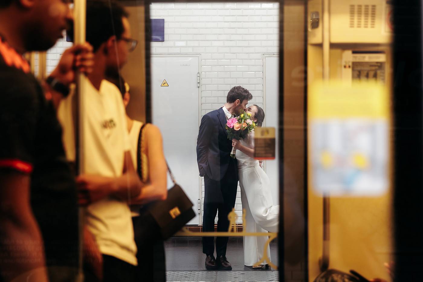 Le baiser des mariés au travers de la rame du métro