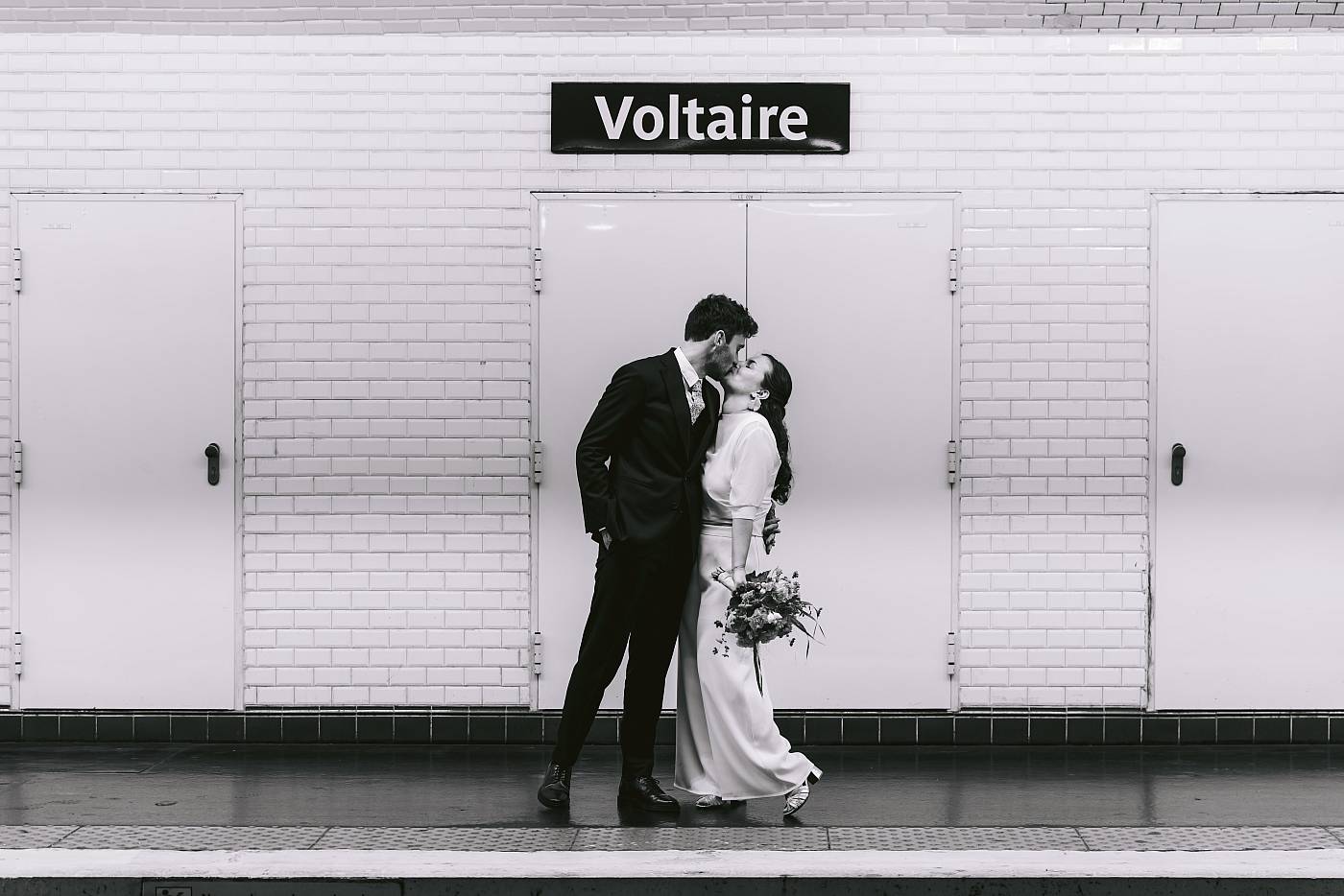 Baiser fougueux des mariés sur le quai du métro à Paris
