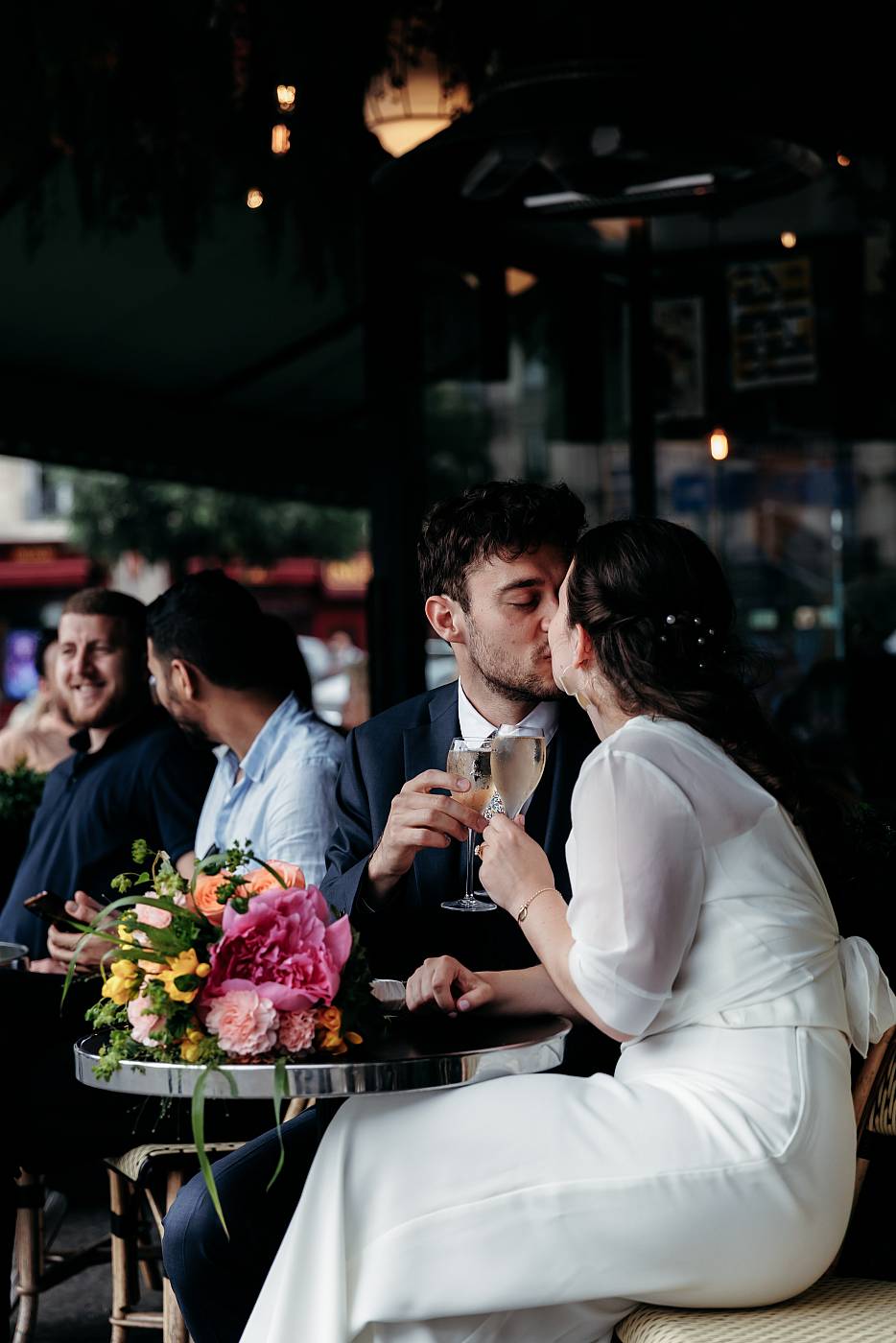 Le baiser des mariés avec une coupe de champagne à la main