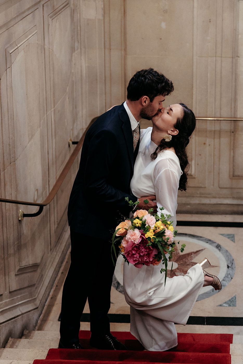 Le baiser des mariés dans les escaliers de la mairie