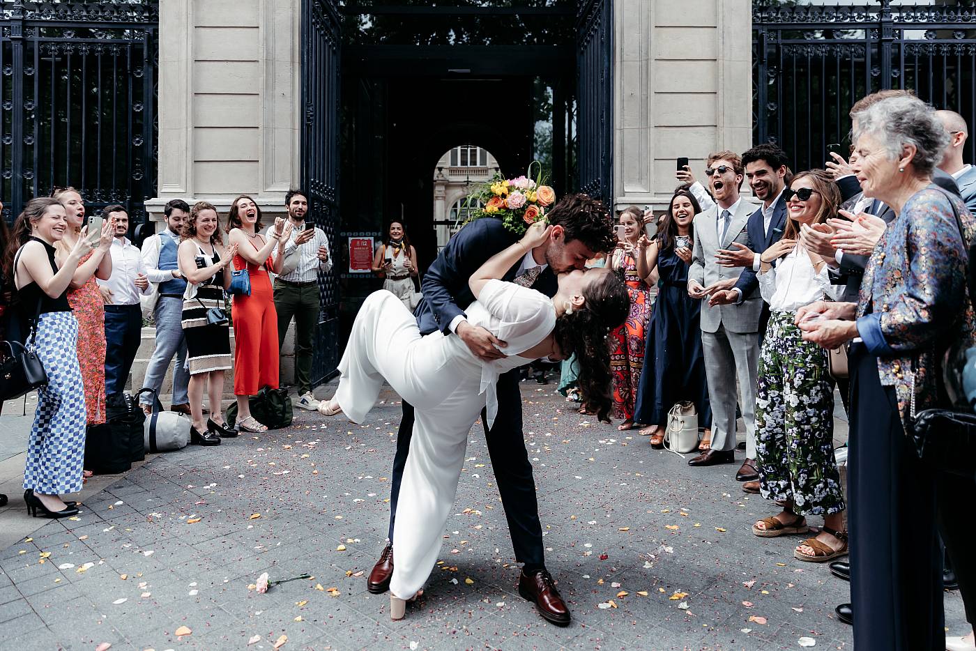 Le baiser fougueux des mariés sous le regard de leurs invités ébahis