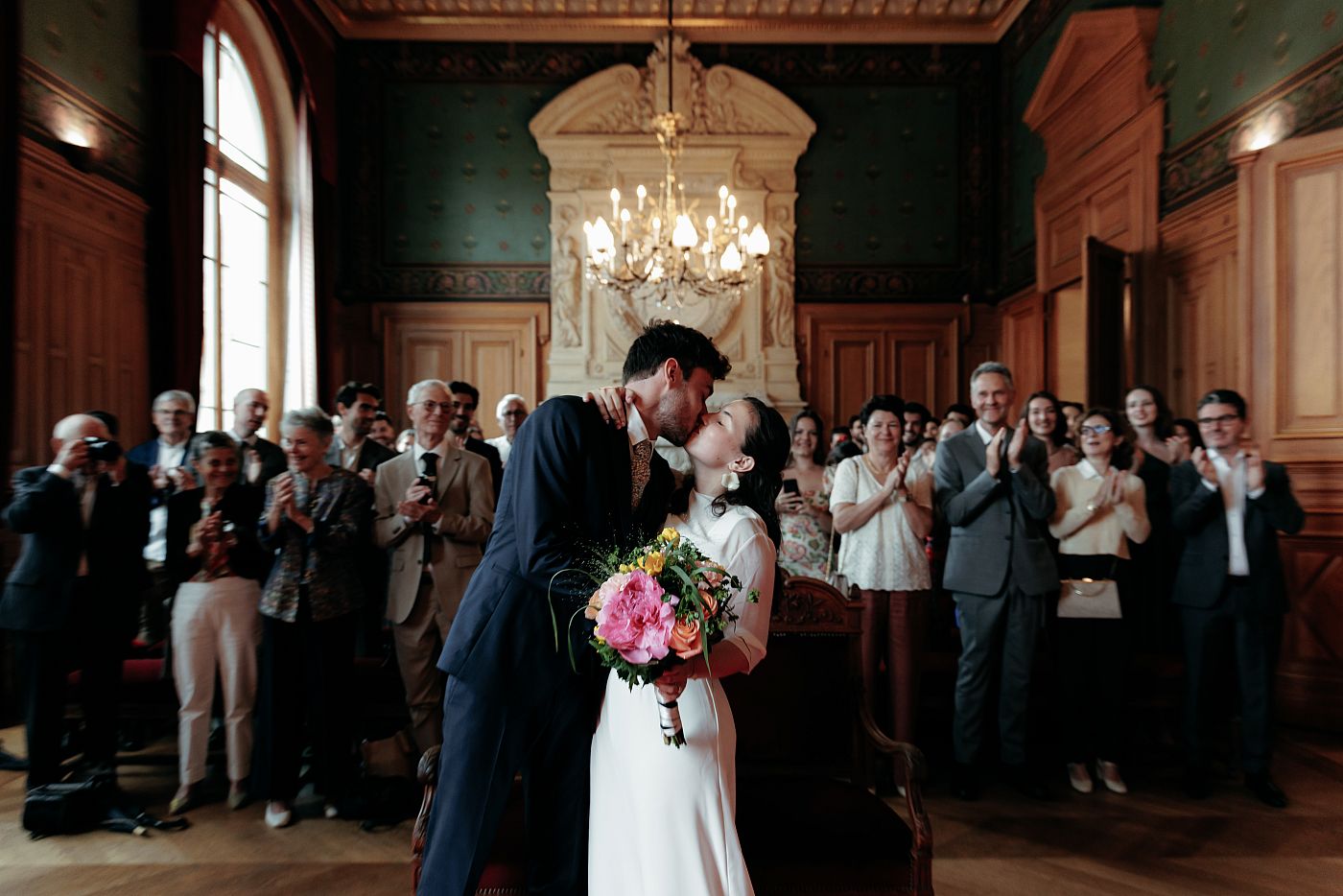 Le baiser des mariés devant la foule qui applaudit