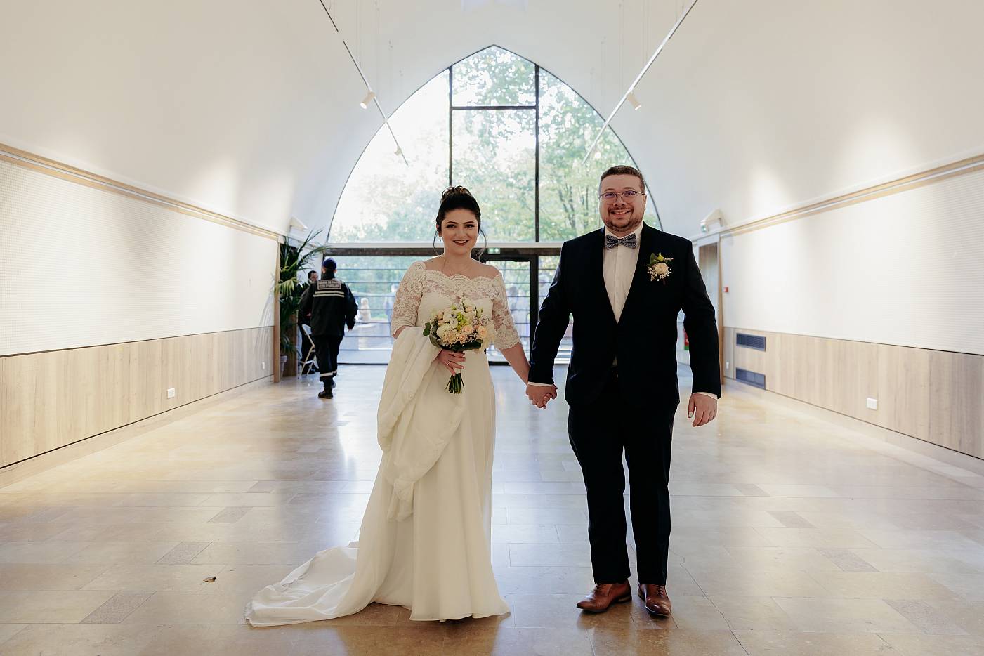 Les mariés entrent main dans la main pour la cérémonie à la mairie