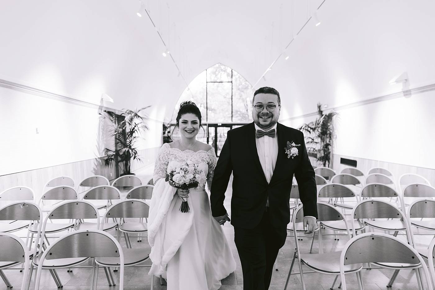 Portrait des mariés rejoignant la cérémonie main dans la main