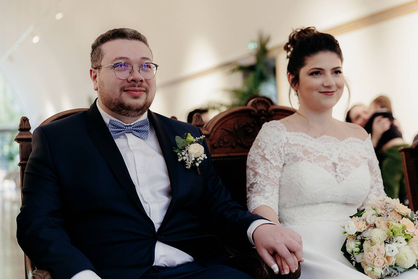 Les mariés se tiennent la main lors de la cérémonie à la mairie