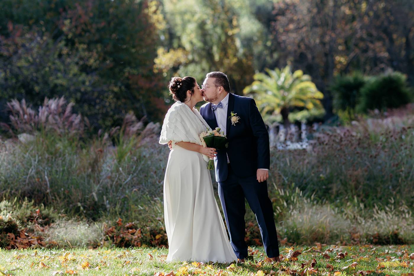 Baiser des mariés durant la séance photo de groupe