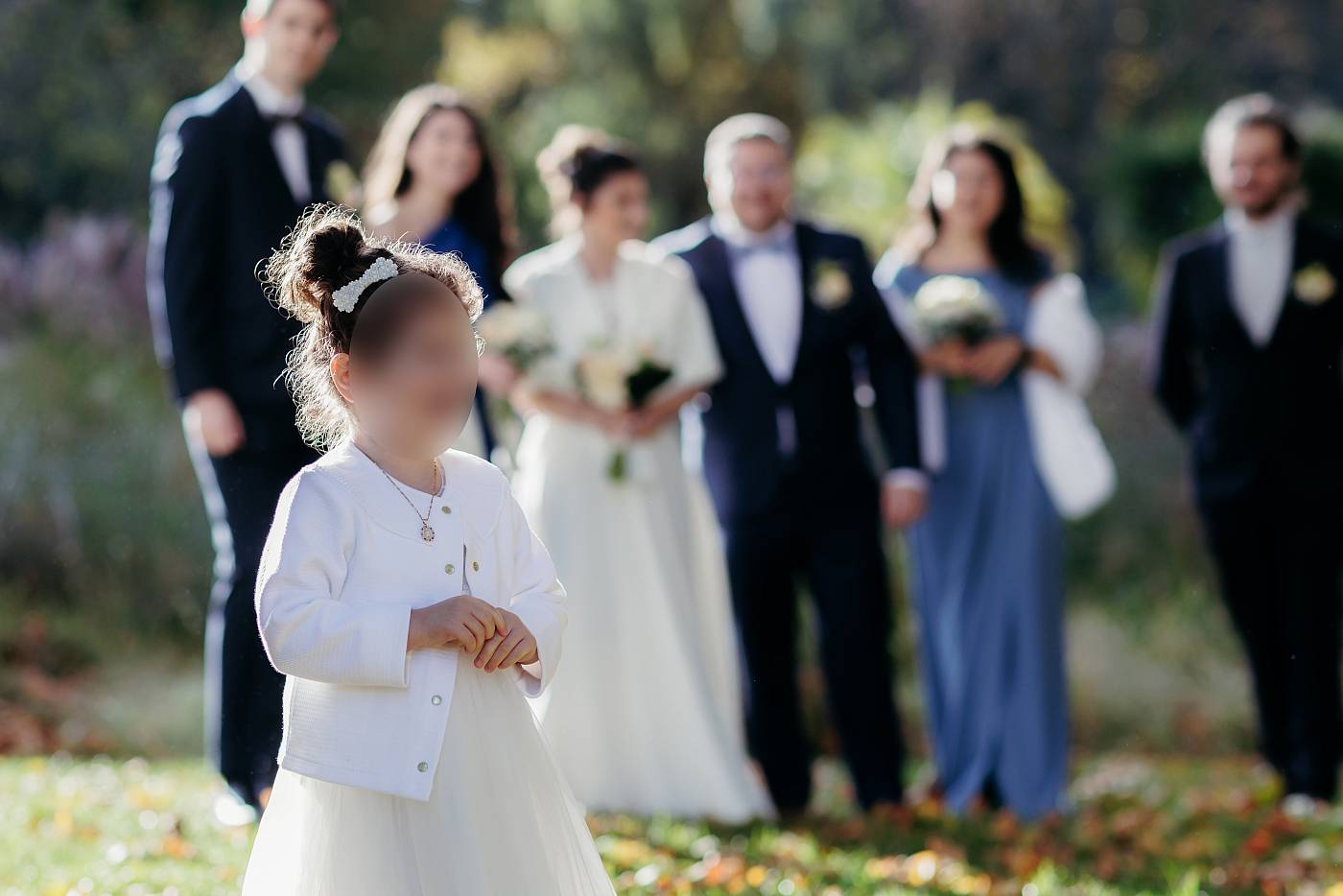Une petite fille s'amuse parmi les invités durant la séance photo de groupe