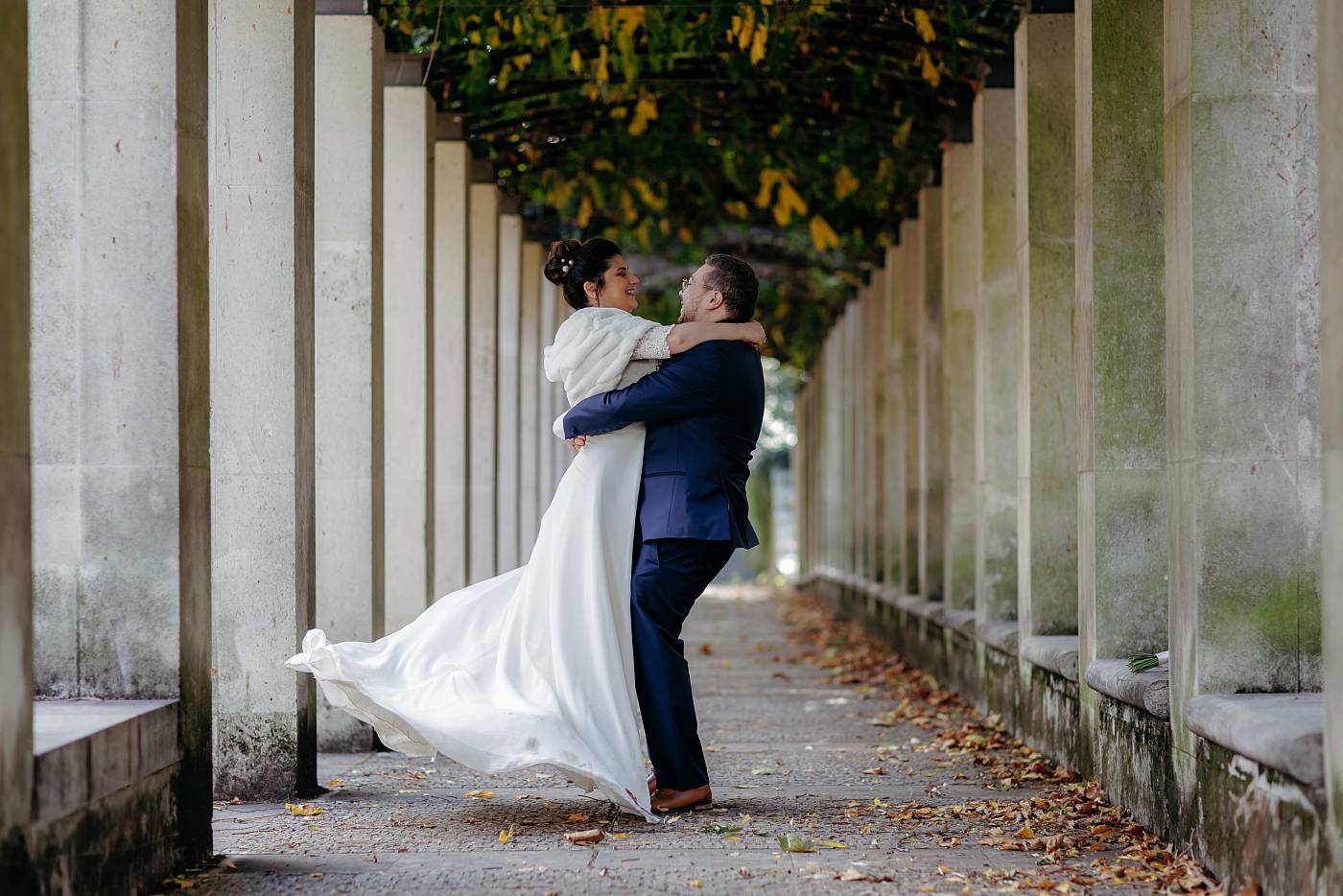 Le marié fait tourner la mariée dans ses bras au parc de Bercy à Paris