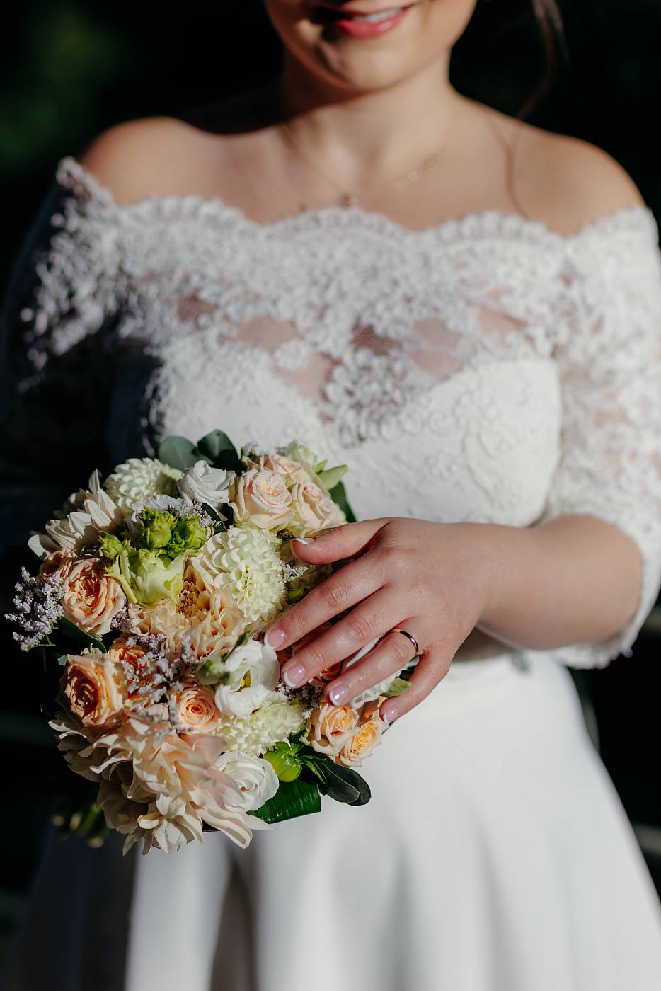 La mariée, son bouquet et son alliance sous une belle lumière