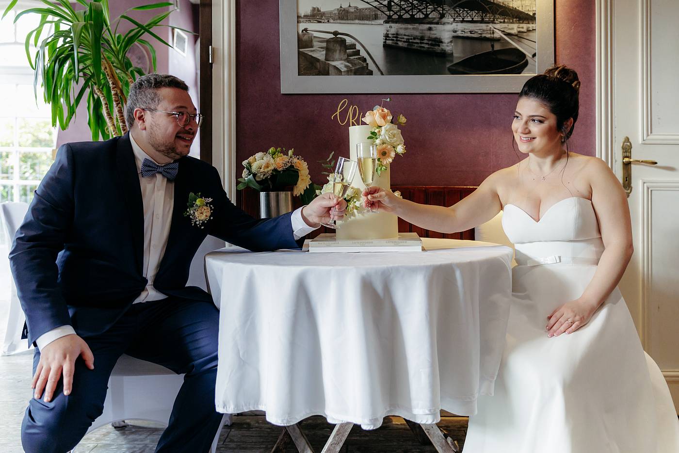 Les mariés trinquent devant la pièce montée