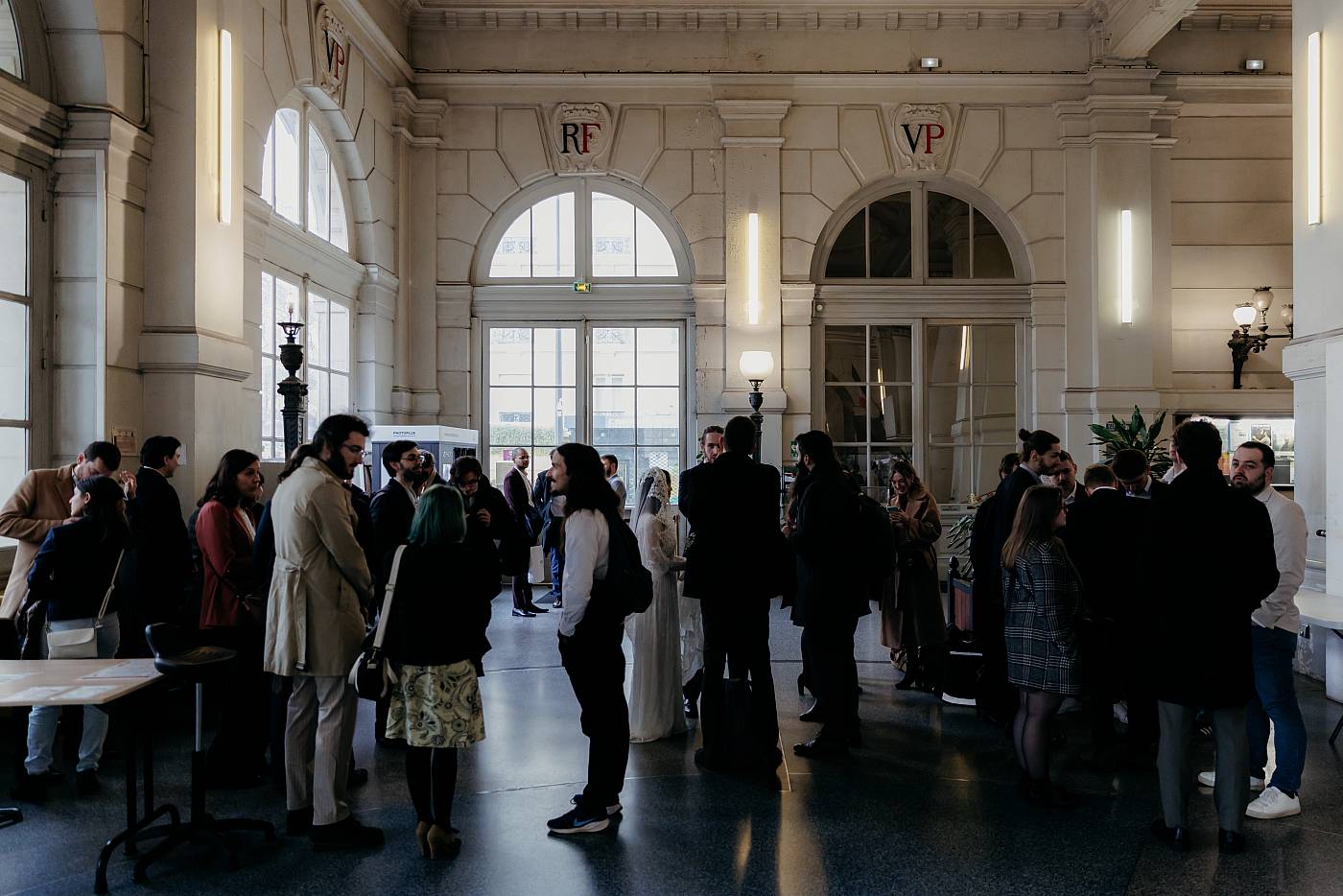 Les mariés et leurs invités rassemblés dans la salle d'entrée de la mairie du 18e