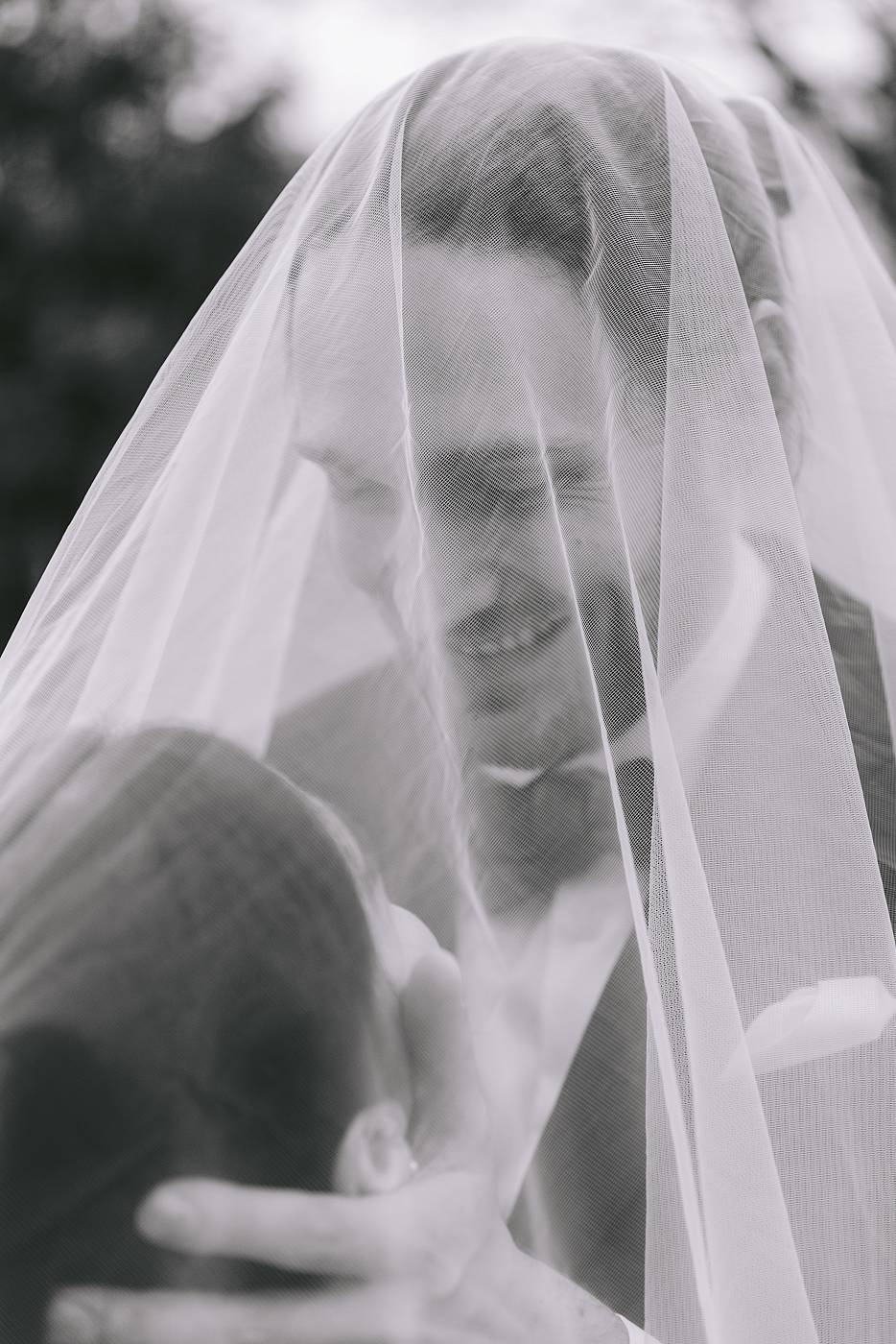 Le sourire du marié sous le voile de la mariée