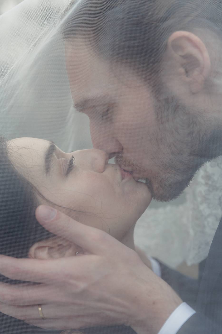 Gros plan des mariés sous le voile de la mariée