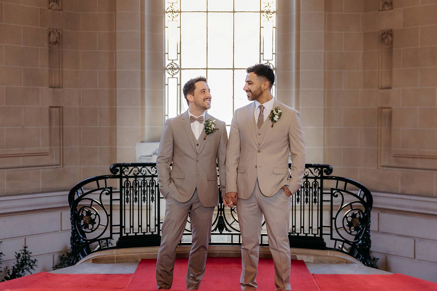Les mariés, les yeux dans les yeux en haut des escaliers de la mairie du 19e arrondissement