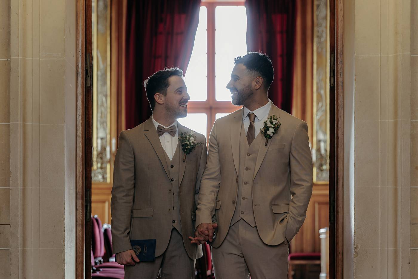 Les mariés main dans la main sur le pas de la porte de la salle de Mariage