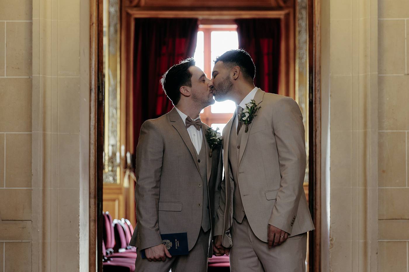 Baiser des mariés en contre-jour à la sortie de la salle des mariages