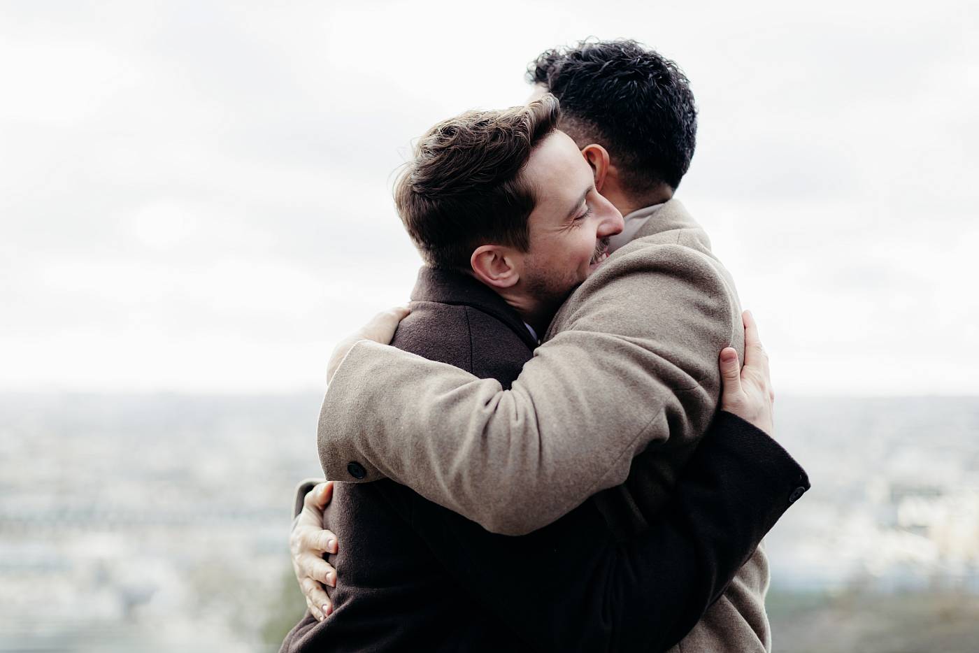 Les mariés se prennent dans les bras l'un de l'autre avec Paris en arrière-plan