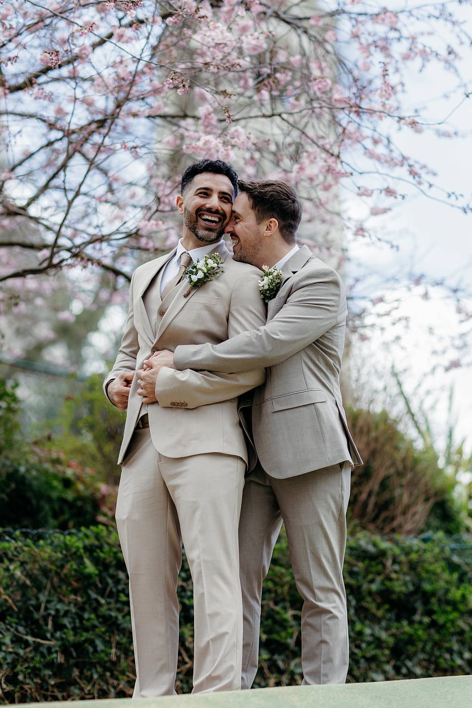 Moment complice des mariés sous un arbre en fleurs dans le parc de la Turlure