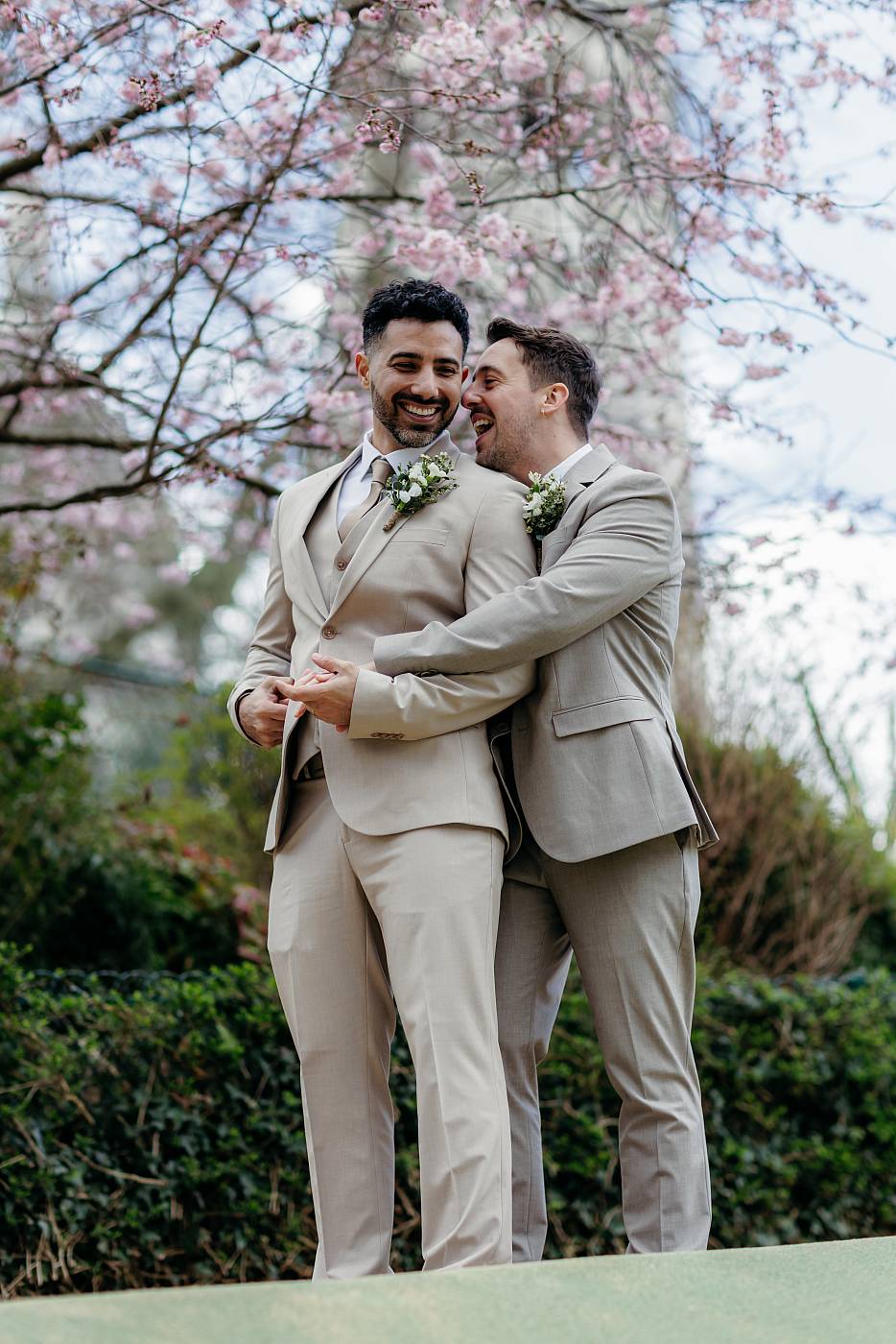 Les mariés s'amusent sous un arbre en fleurs