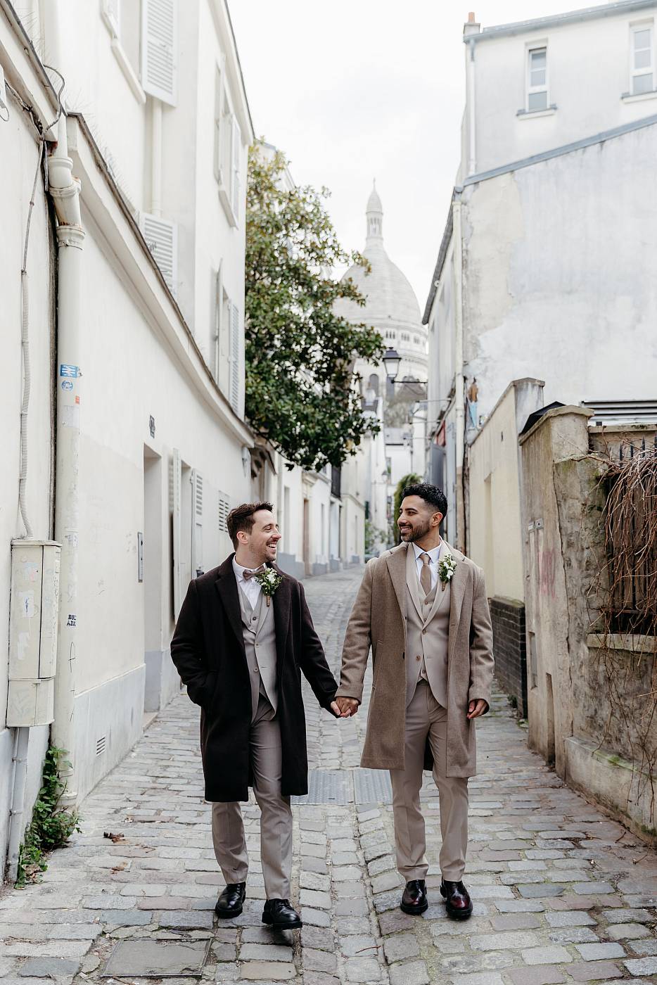 Les mariés se baladent main dans la main dans les rues de Montmartre