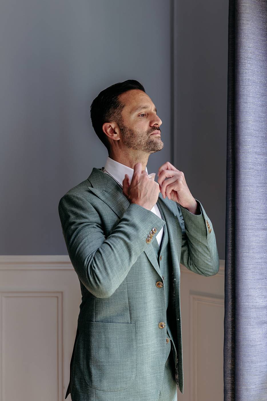 Le marié se prépare devant sa fenêtre