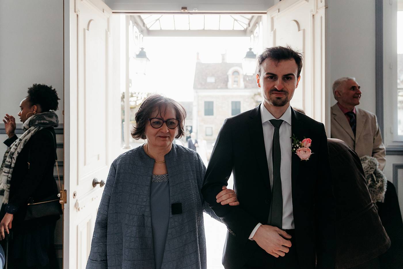 Le marié entre dans la mairie accompagné de sa mère