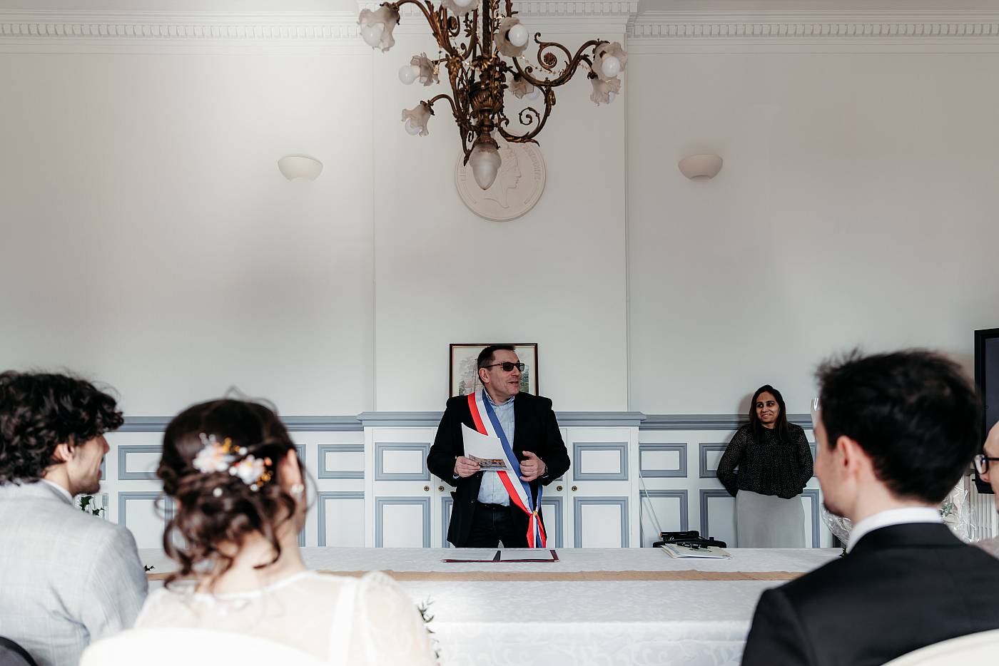 Monsieur le maire et les mariés vu de dos