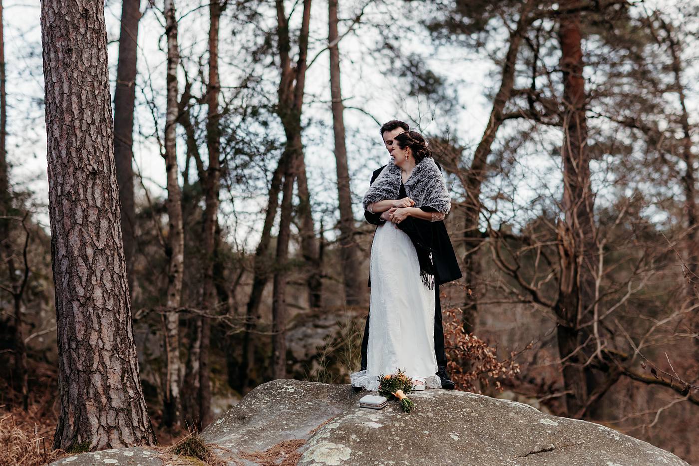 Les mariés prennent la pause sur une grosse pierre caractéristique de la forêt de Fontainebleau