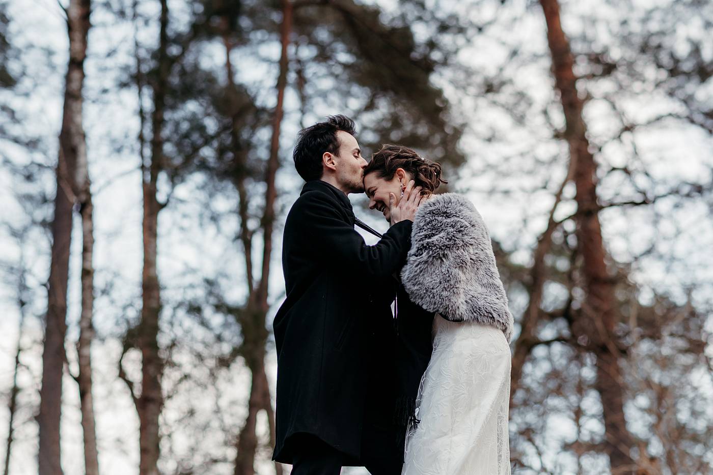 Le marié embrasse la mariée sur le front