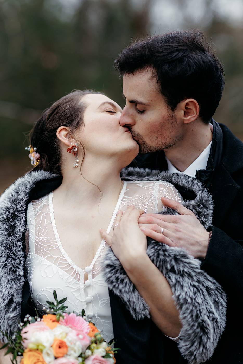 Les mariés s'embrassent en montrant leurs alliances