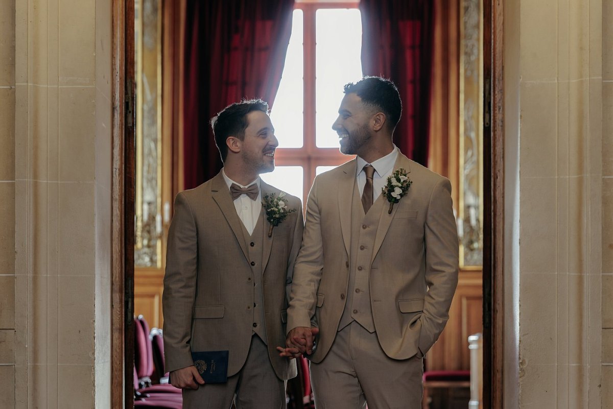 Les mariés main dans la main sur le pas de la porte de la salle de Mariage