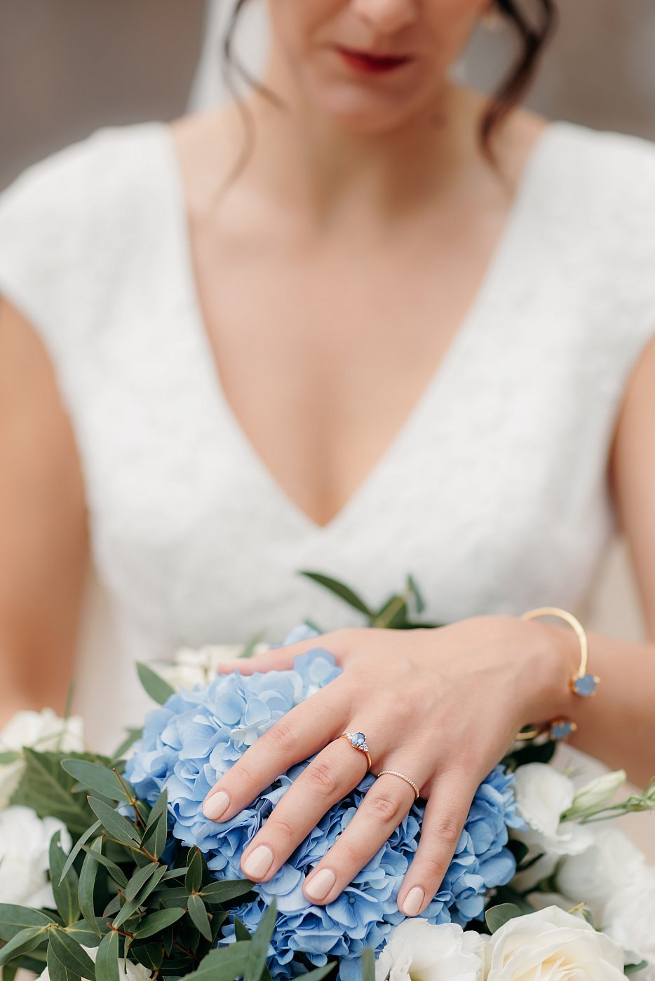 Gros plan sur le bouquet et l'alliance de la mariée