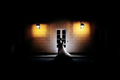 Photo des mariés de nuit avec la façade du domaine