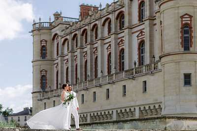 Les mariés posant devant le château