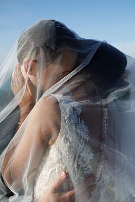 Les mariés sous le voile pendant la séance photo de couple