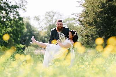 Les mariés s'amusent dans un champ de fleurs